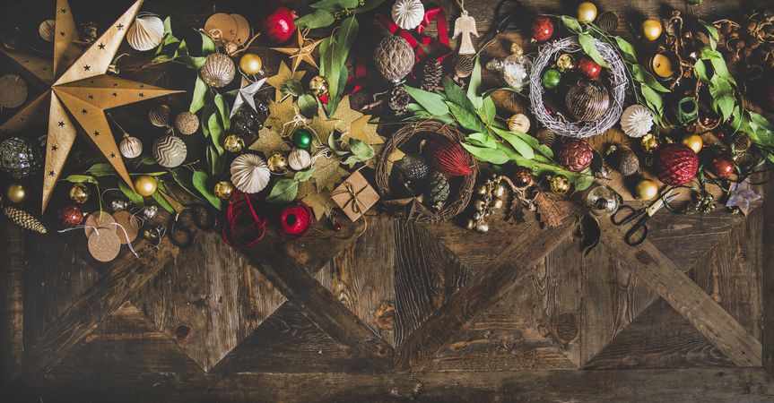 Holiday decorations of stars, baubles, leaves, scissors and ribbon, with copy space