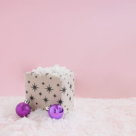 Starry giftwrap present with decorations sitting in snow