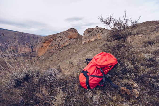 Bright backpack at mountain slope
