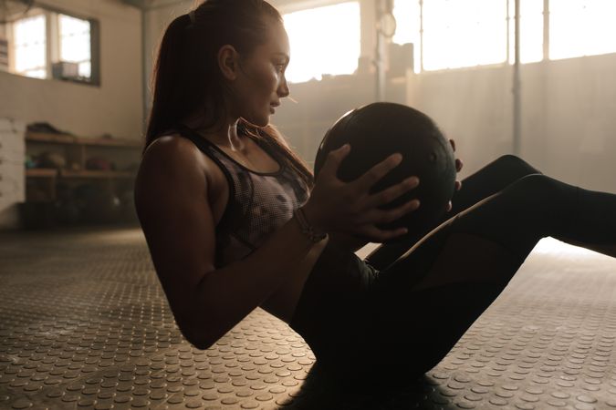 Determined woman exercising with medicine ball in gym