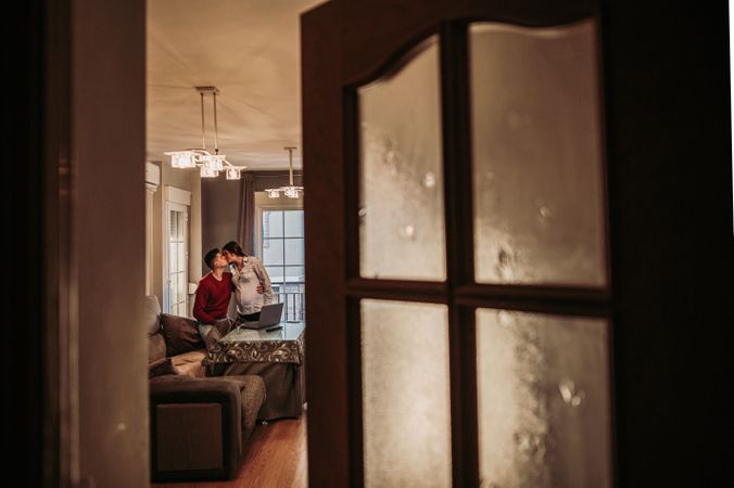 Couple expecting baby kissing at home