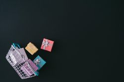 Shopping basket with several wrapped presents on dark background