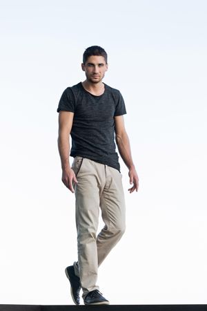 Full body portrait of male in t-shirt and slacks on bright background