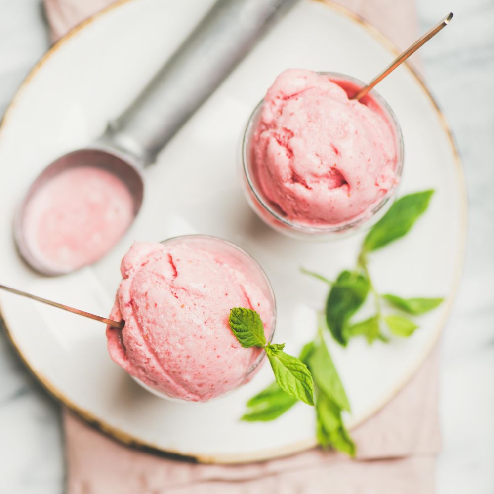 Homemade strawberry yogurt ice cream with fresh mint, square crop