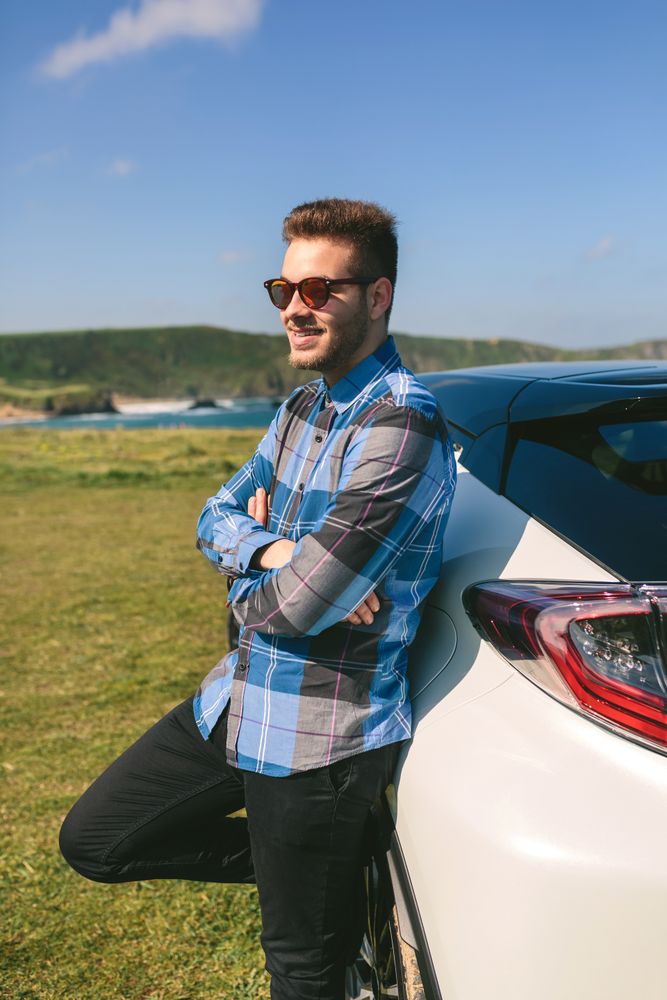 young man leaning on his car