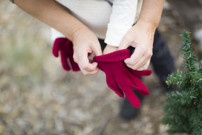 Mother Putting Red Mittens On Child
