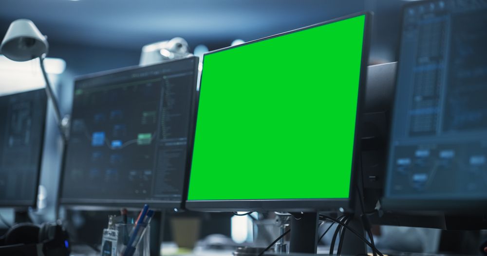 Empty Software Developer Office Workplace with a Desk with Computer Green Screen.