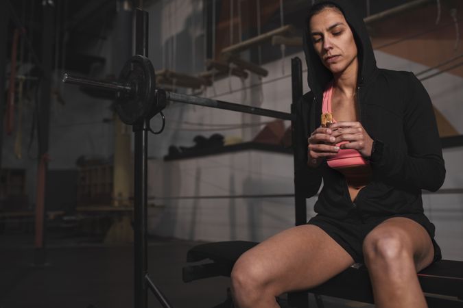 Smiling woman with energy bar in gym