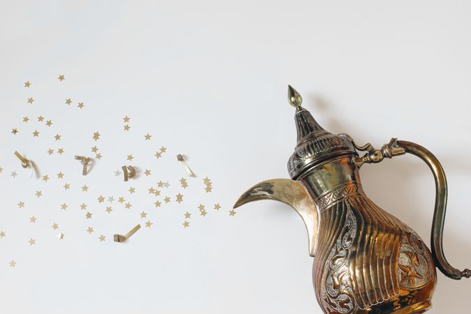Traditional ornamental Arabic dallah coffee pot with bursting golden stars