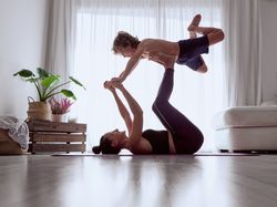 Mother and son doing acro yoga together