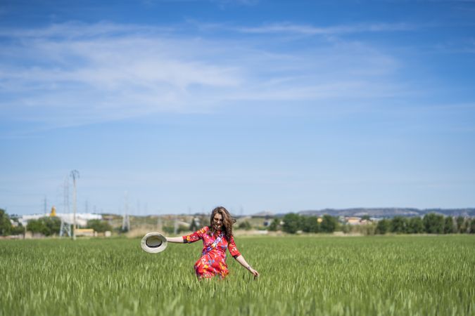 Young woman throwing up hat in field