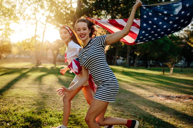 Two girls with USA flag enjoying outdoors