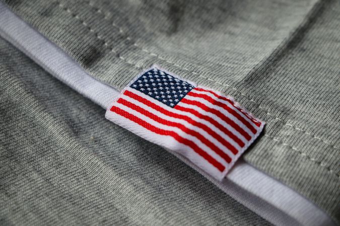 Embroidered American flag on grey fabric. USA flag on grey fabric background.