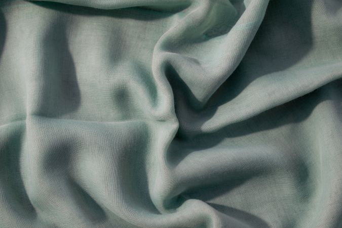 Nude green fabric wavy crumpled background texture with copy space.