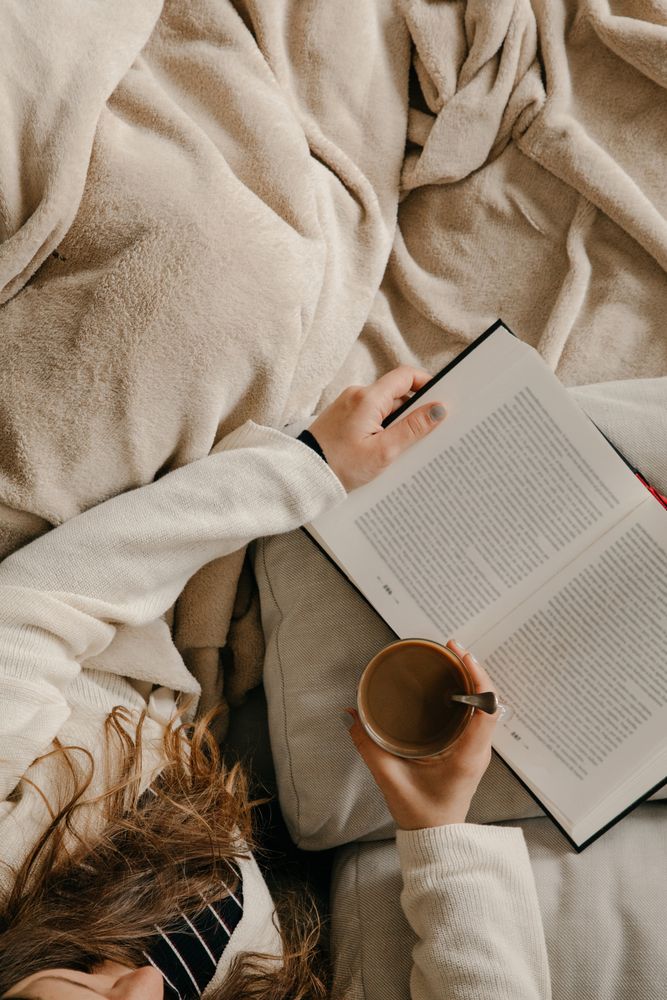 Person reading a book on the bed