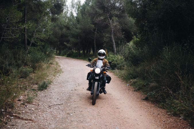 Person on motor bike in forest path