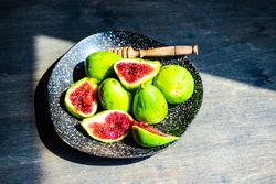 Top view of fresh figs on plate in sunny kitchen