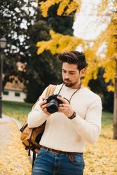 Trendy male with backpack and camera