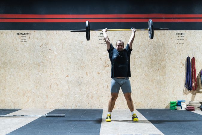 Muscular sportsman lifting heavy barbell