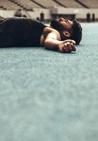 Athlete lying on the track resting after a race