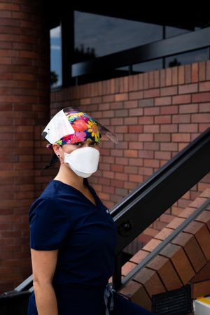 Portrait of Asian female nurse in PPE standing outside of medical building