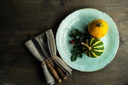 Top view of teal plate with mini squashes and cutlery