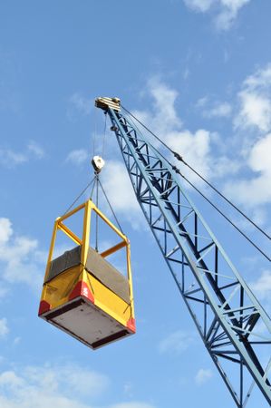 Crane carrying a yellow box