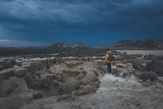 Man standing on stone in desert hills