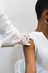 Doctor making injection for Black woman patient