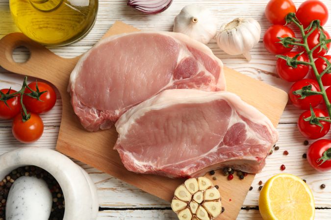 Composition with raw meat for steak and ingredients on wooden background