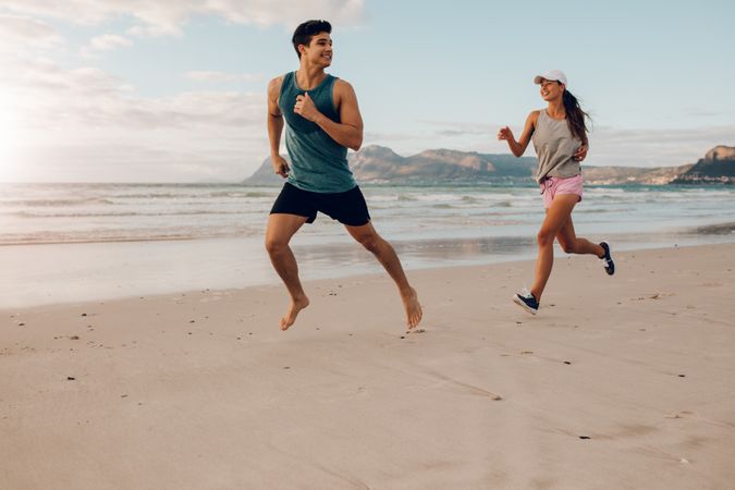 Fitness couple running on the beach