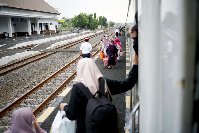 Indonesian people exiting and boarding train at the station in