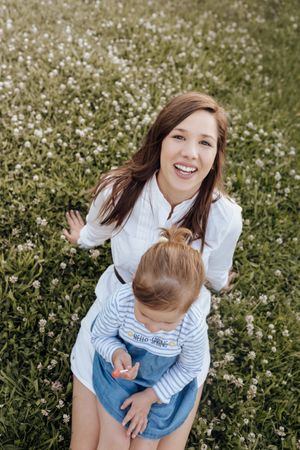 Mother and daughter sitting on lawn
