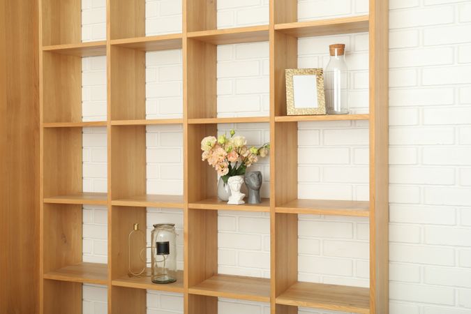 Wooden shelves with different items against brick wall
