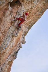 Anonymous strong man climbing on rock in mountains