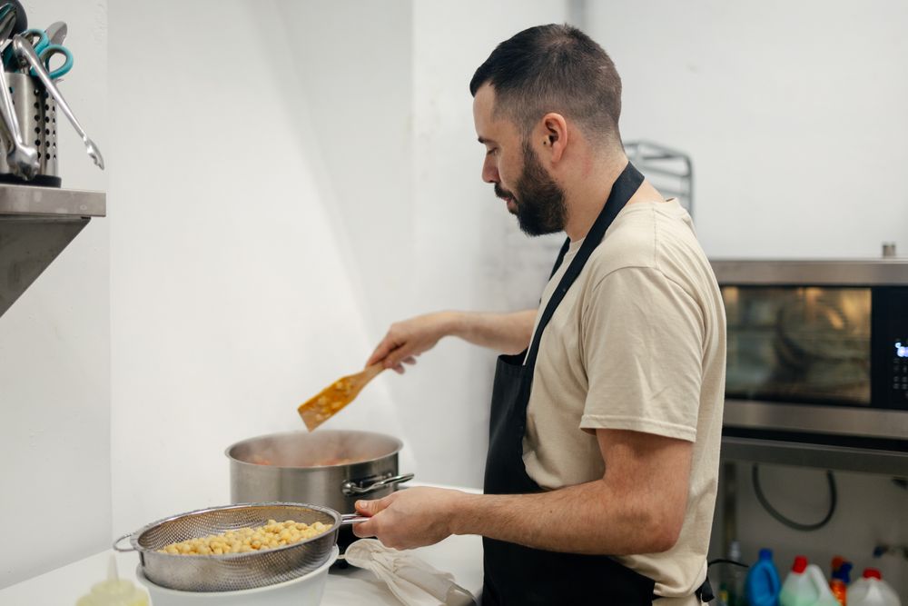 Young chef cooking with a casserole