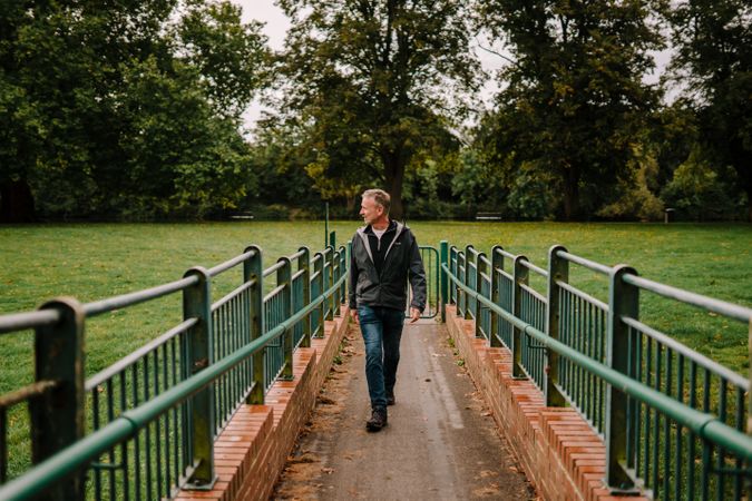 Man walking on pedestrian bridge in park