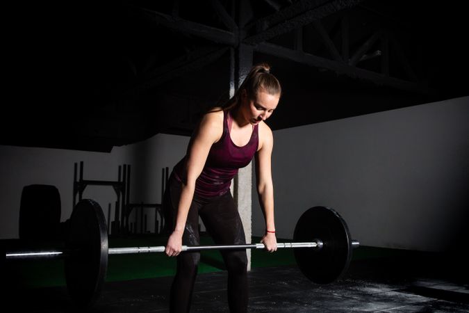Woman lifting barbell in gym