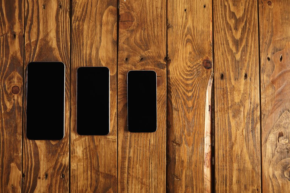 Three cellphones laying on table