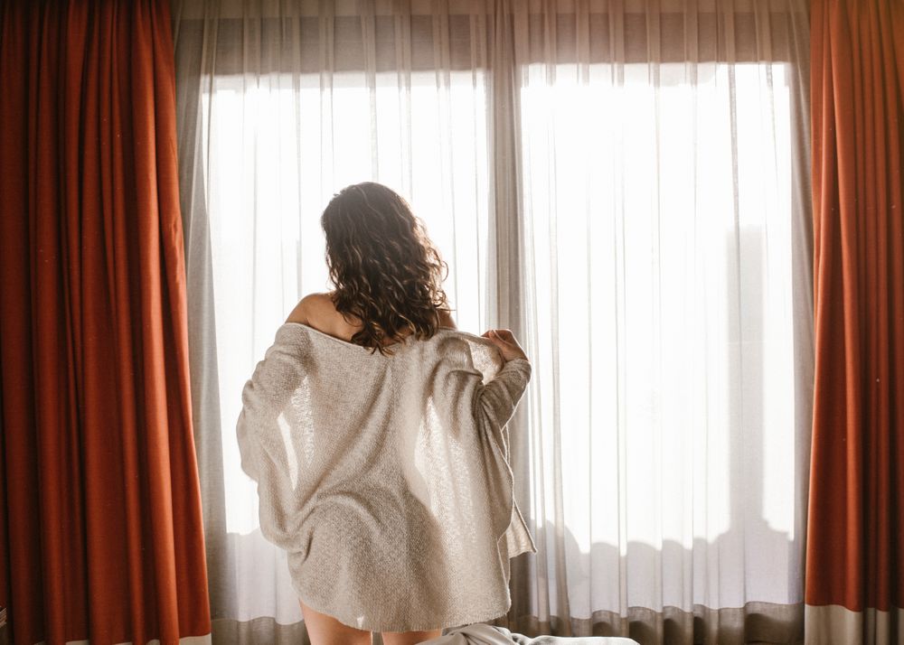 Woman waking up taking off cardigan
