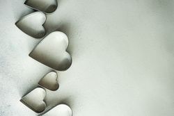Top view of heart shaped cookie cutters on grey counter