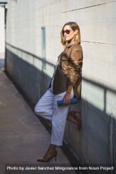 Chic woman leaning on wall with shadow 4AzM3z