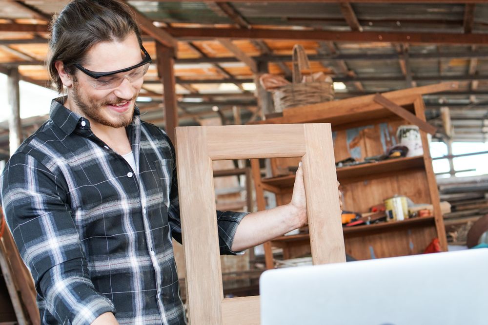 Smiling man with picture frame he made