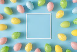 Colorful Easter eggs with square frame and pastel blue background