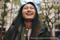 Young Asian woman laughing with eyes closed bDPQQb