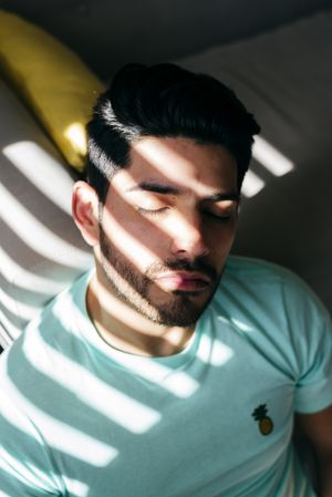 Young sad man sitting on couch at home