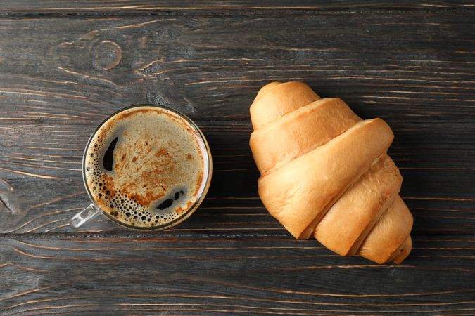 Tasty croissant on wooden background, top view