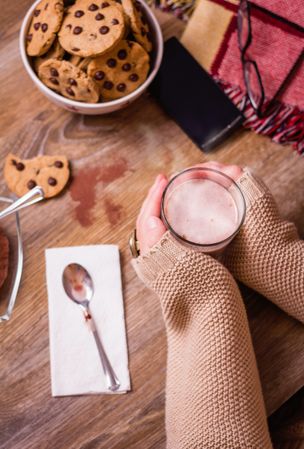 Female hands with hot drink and chocolate cookies
