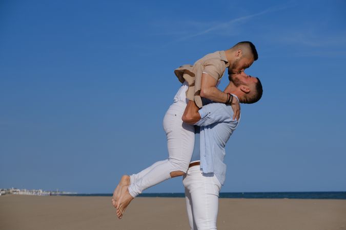 Gay couple hugging on beach
