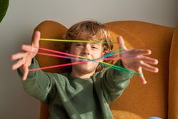 Content boy showing string on fingers